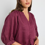 model wears burgundy blouse