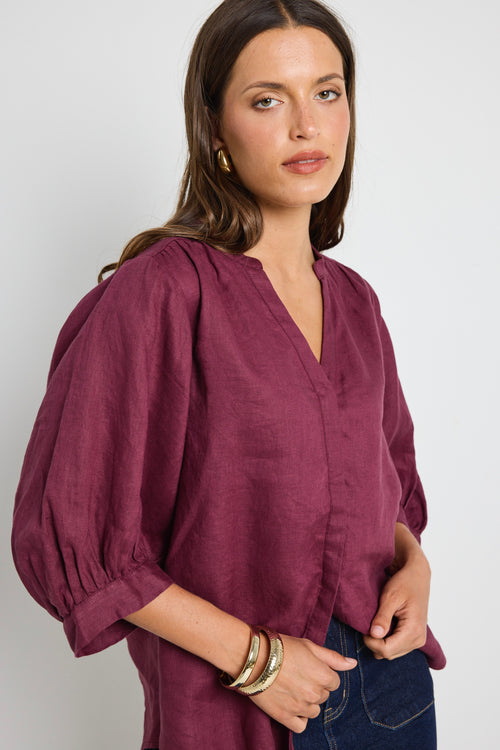 model wears burgundy blouse