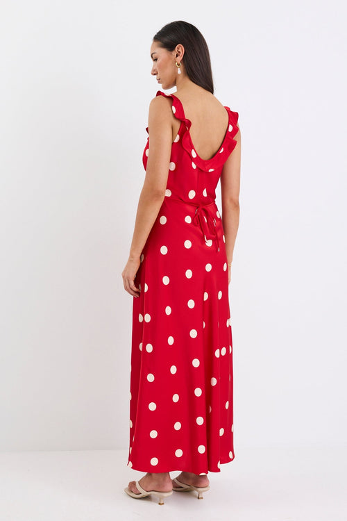Woman wearing a red polka dot dress on a white background