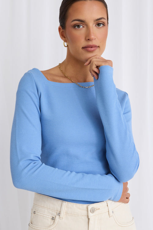model wears a blue long sleeve top