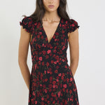 Woman wearing a black floral dress on a white background