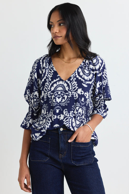 model wears a navy print blouse