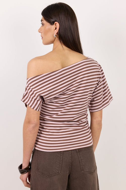 A woman shown from the back wearing a brown and white horizontally striped off-the-shoulder top and brown pants, standing against a plain light background.