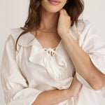 Model wears a white ruffle top