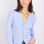 Woman wearing a light blue cardigan with a white background