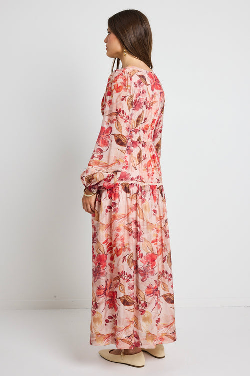 model wears a blush floral tiered dress