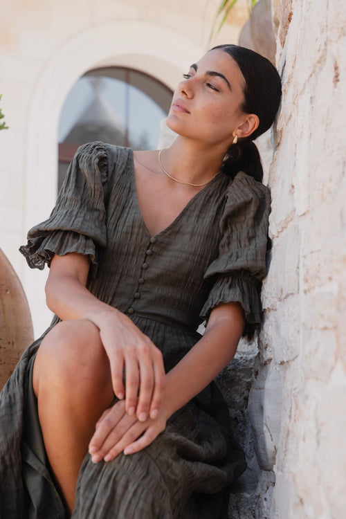 model wears a green midi dress