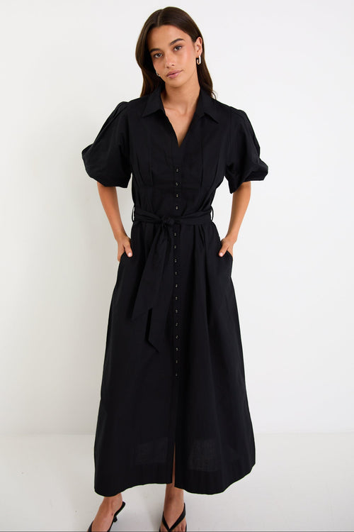 Woman wearing a black dress against a white background