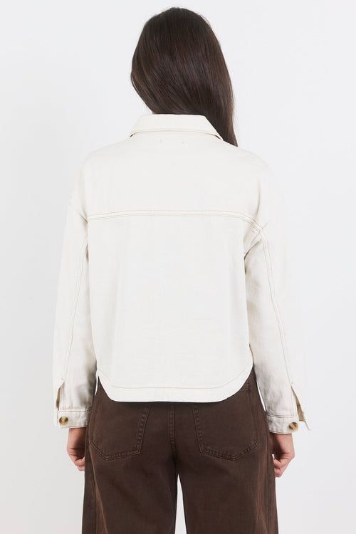 Person wearing a white jacket and brown pants on a white background