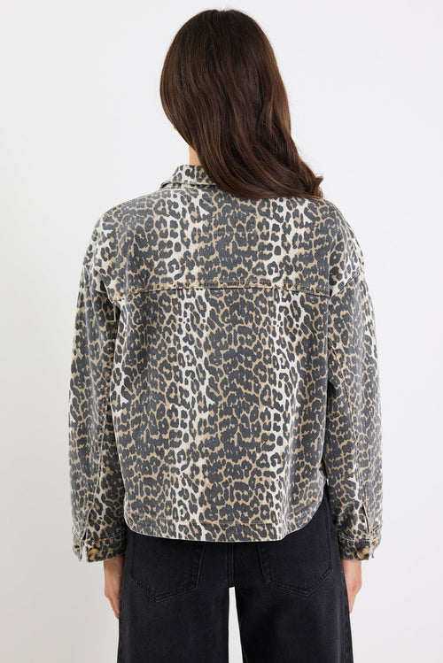 Person wearing a leopard print shirt against a white background