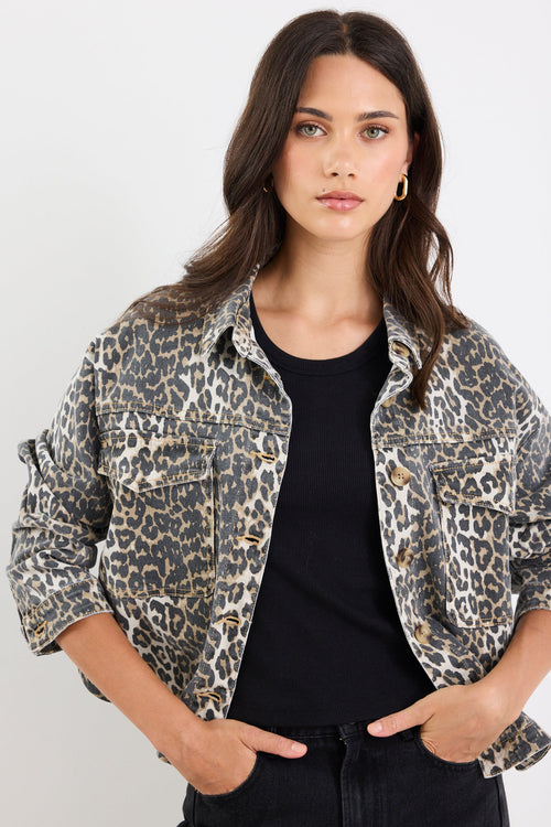Woman wearing a leopard print jacket over a black top on a white background