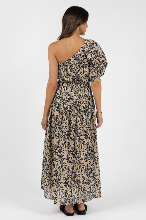 model wears a navy floral one shoulder maxi dress