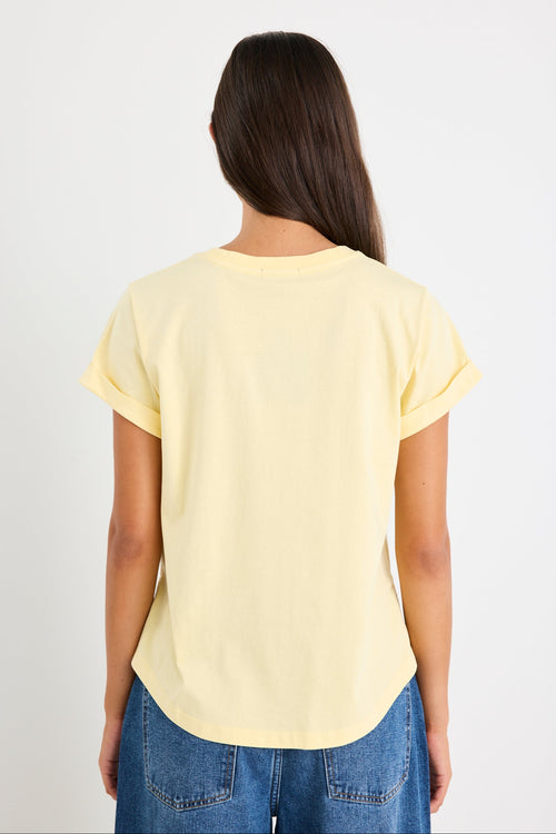 Woman wearing a yellow tee and blue jeans
