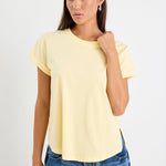 Woman wearing a yellow tee and blue jeans