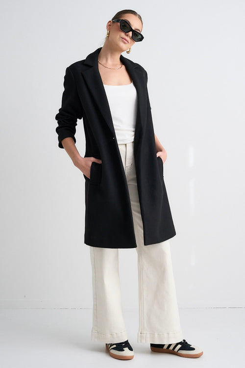 Model wears a black long coat 