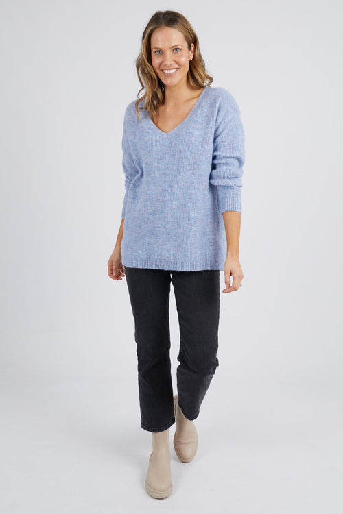 Model wears a v neckline knit jumper in a pastel blue