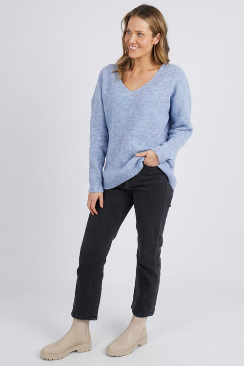Model wears a v neckline knit jumper in a pastel blue