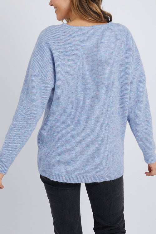 Model wears a v neckline knit jumper in a pastel blue