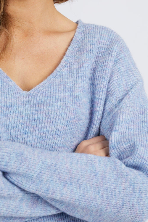 Model wears a v neckline knit jumper in a pastel blue