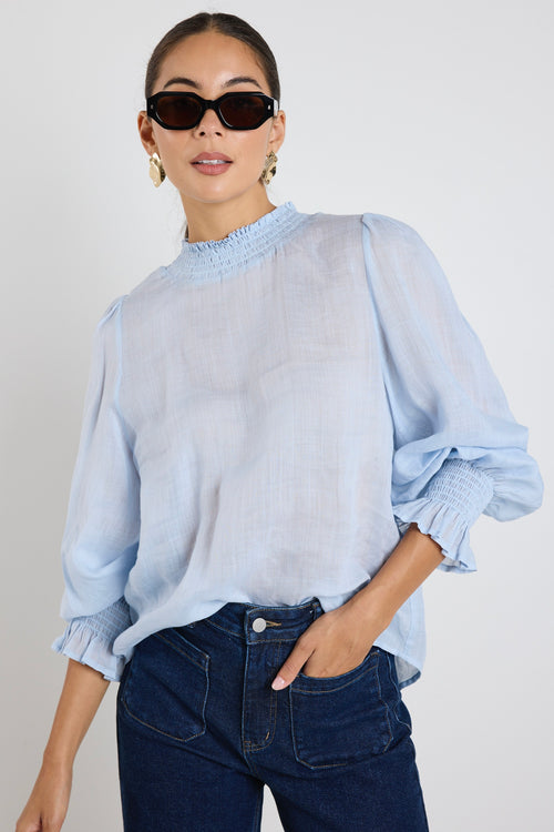 Model wears a blue blouse 