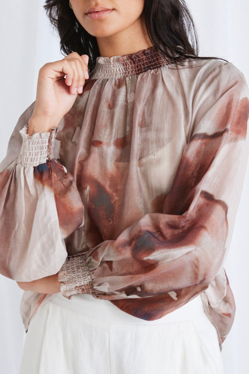 model wears a brown print blouse