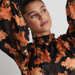 model wears a black floral top