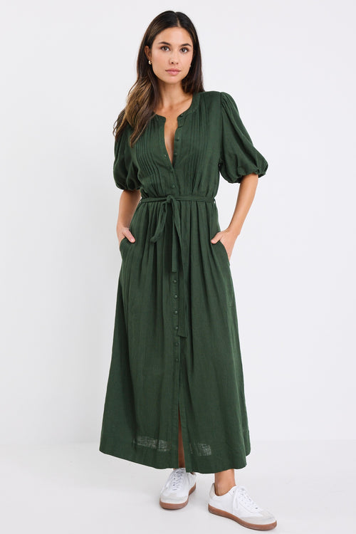 Woman wearing a forest green short sleeve midi shirt dress with puff sleeves, button front and waist tie.