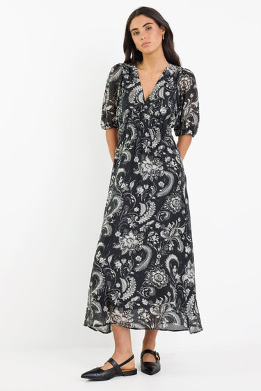 Woman wearing a black and white patterned dress on a white background