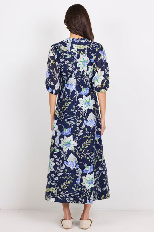 Woman wearing a navy floral dress against a white background