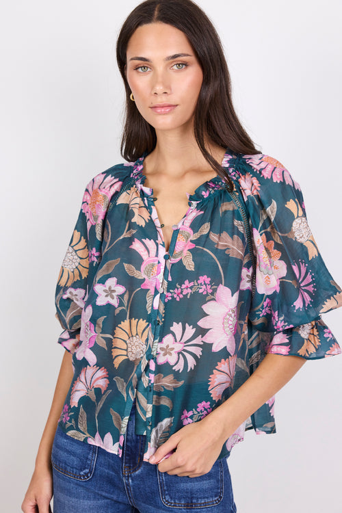 Woman wearing a floral blouse with a plain background