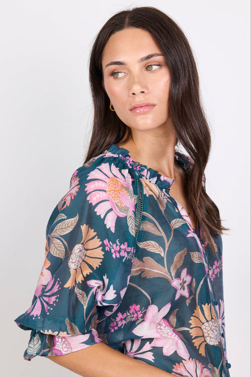Woman wearing a floral blouse against a white background