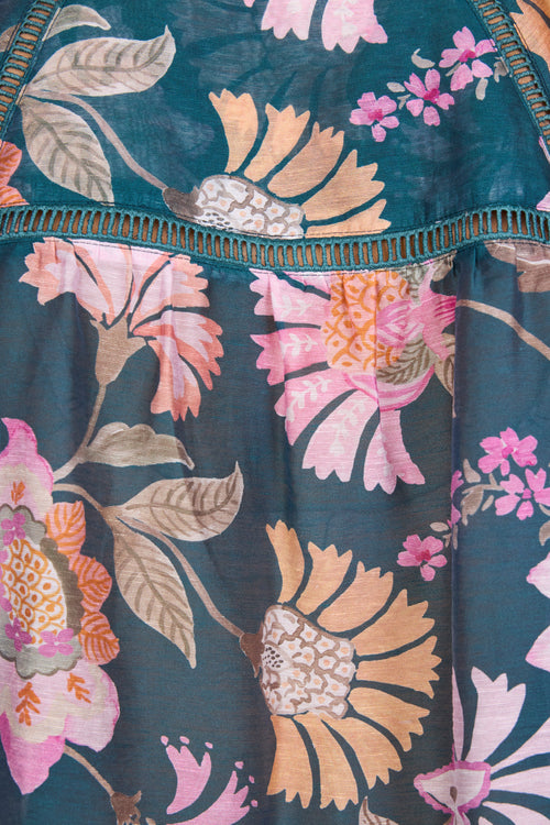 Floral patterned fabric with pink, orange, and green flowers on a dark blue background.