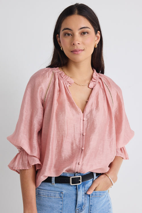 model wears a pink blouse