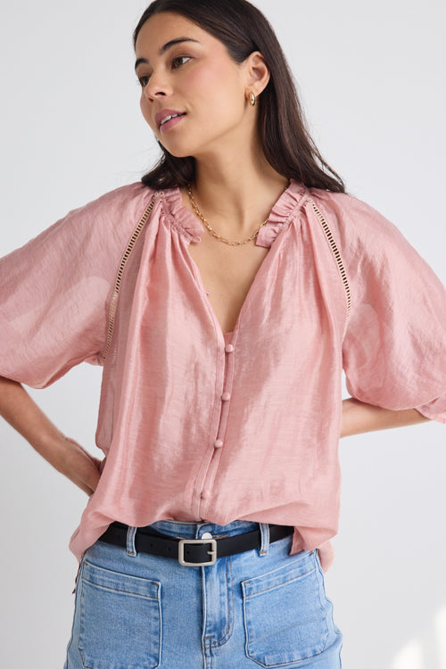 model wears a pink blouse