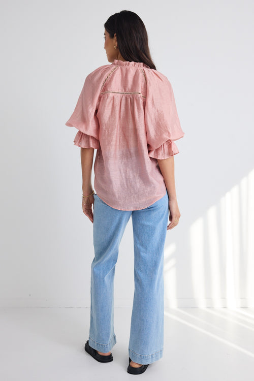 model wears a pink blouse