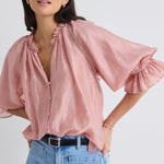 model wears a pink blouse