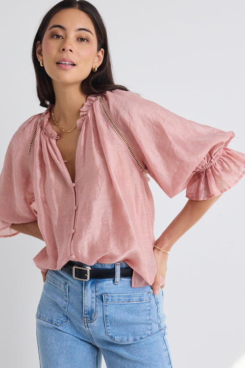 model wears a pink blouse