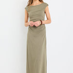 Woman wearing a sleeveless khaki midi dress with boat neckline and ruched side detailing, styled with black strappy sandals.