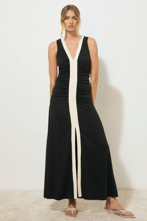 Black sleeveless midi dress with a low V-neckline, contrast cream band detail down the centre front, ruched bodice, and front hem split, worn by a model standing against a white background.