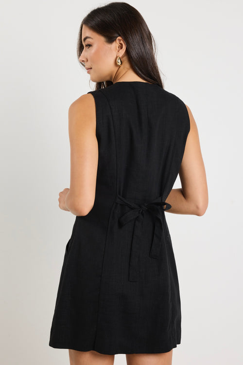 model wears a black linen mini dress