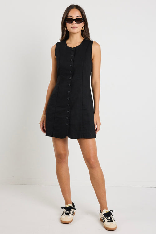 model wears a black linen mini dress