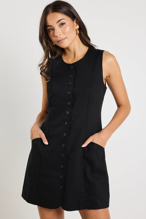 model wears a black linen mini dress