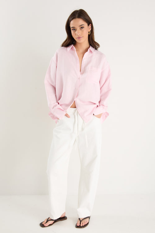 Women wears a pink shirt with white jeans 