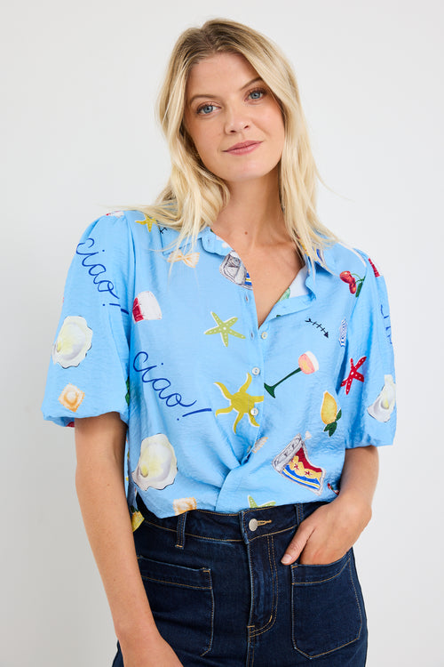 model wears a blue printed tie up puff sleeve shirt with dark blue jeans