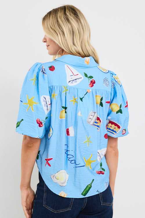 model wears a blue printed tie up puff sleeve shirt with dark blue jeans