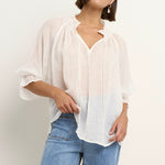 model wears a white blouse with light blue jeans
col_pattern