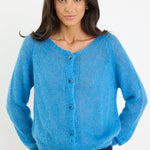 Woman wearing a blue knitted cardigan on a white background
