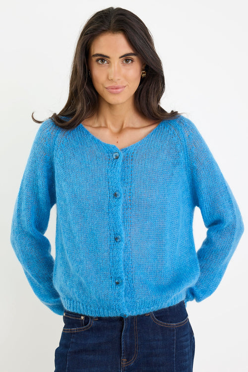 Woman wearing a blue knitted cardigan on a white background