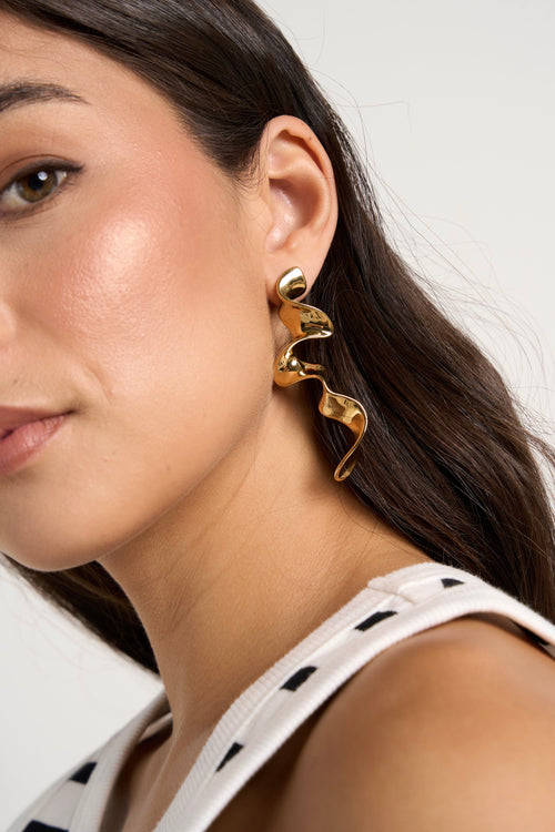 model wears gold earrings