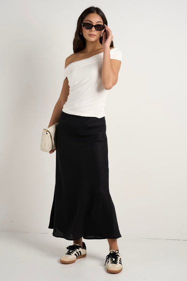 model wears a black linen midi skirt